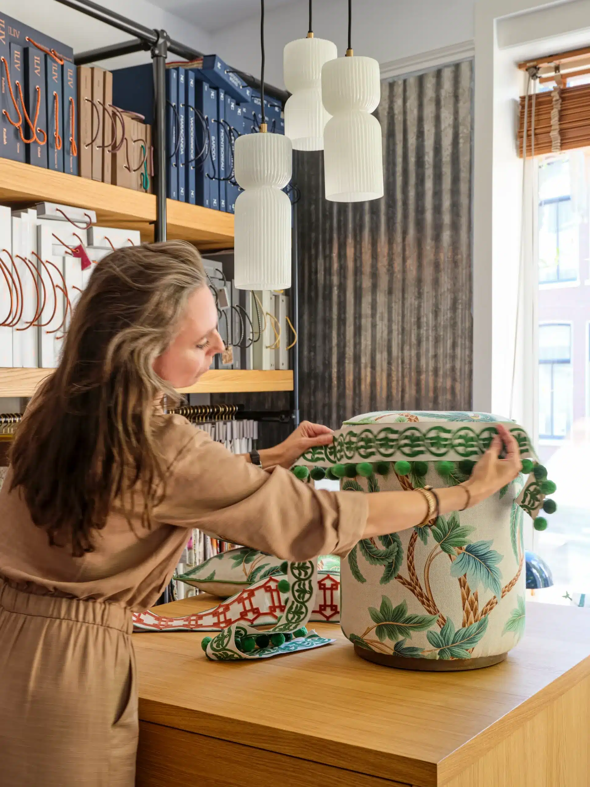 Interieuradviseur stylt plantenpot in modern ingericht woonkamer met houten meubels en groene planten