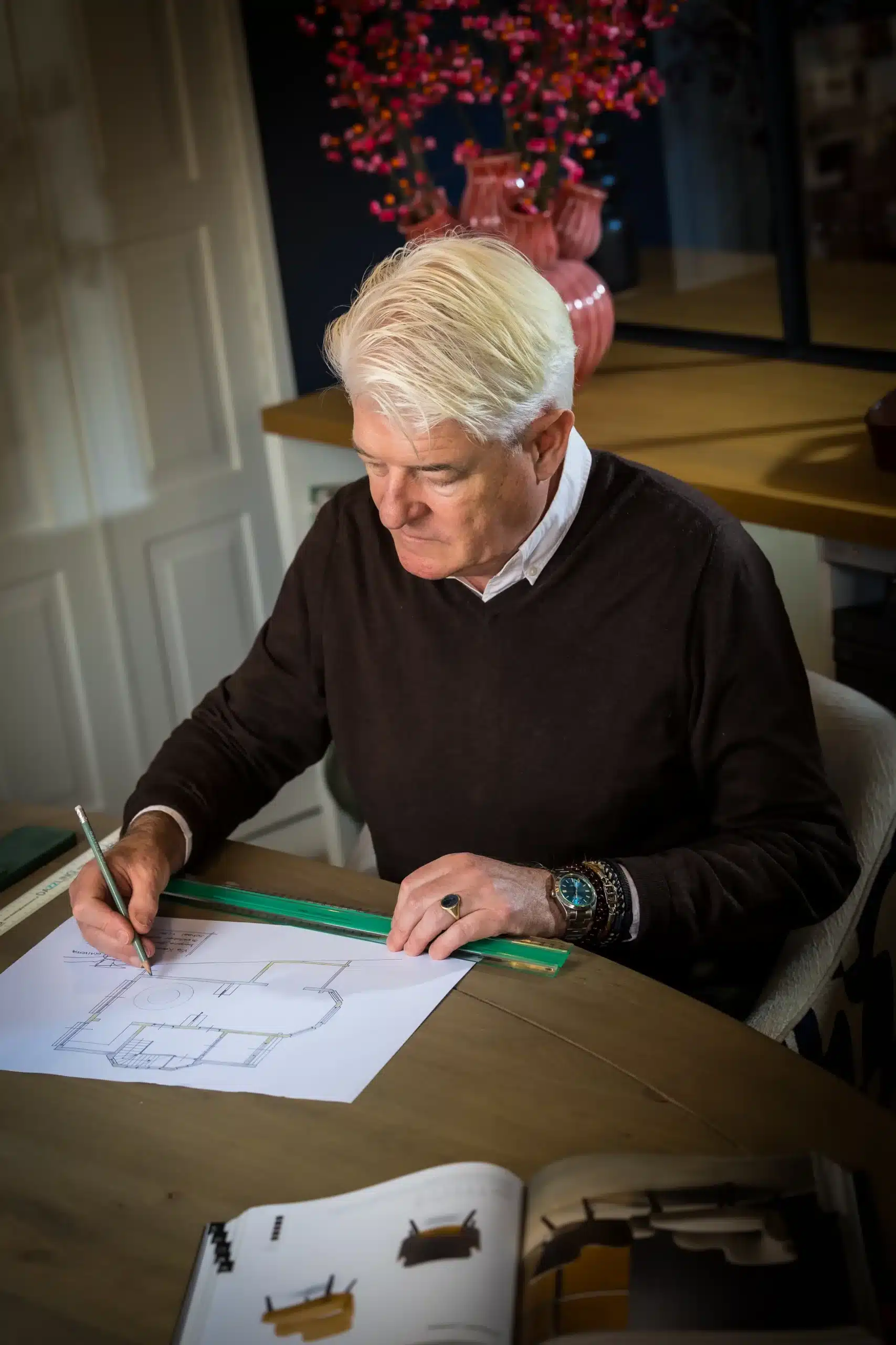 Interieuradviseur schetst ontwerpplan aan tekentafel voor maatwerk interieurontwerp